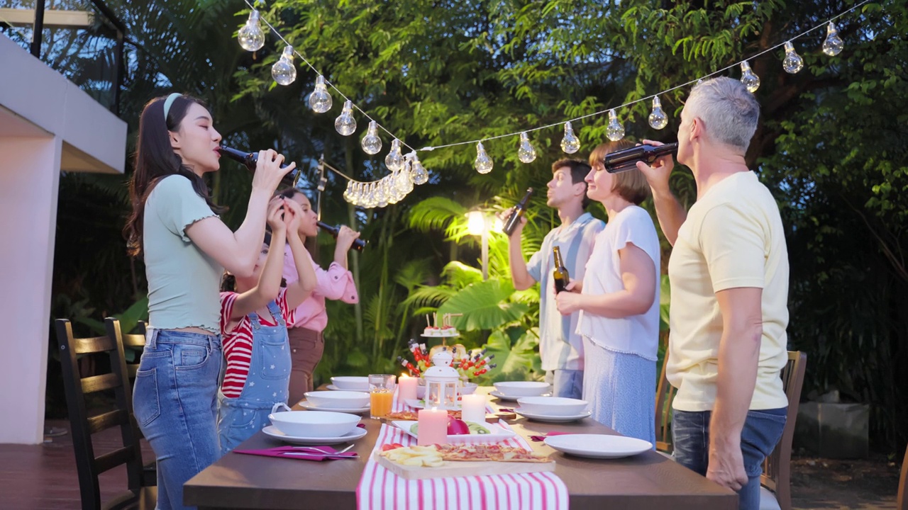 多民族大家庭在户外花园欢聚。各式各样诱人的人聚在一起聚餐，吃着美食，欢度周末团聚。视频素材
