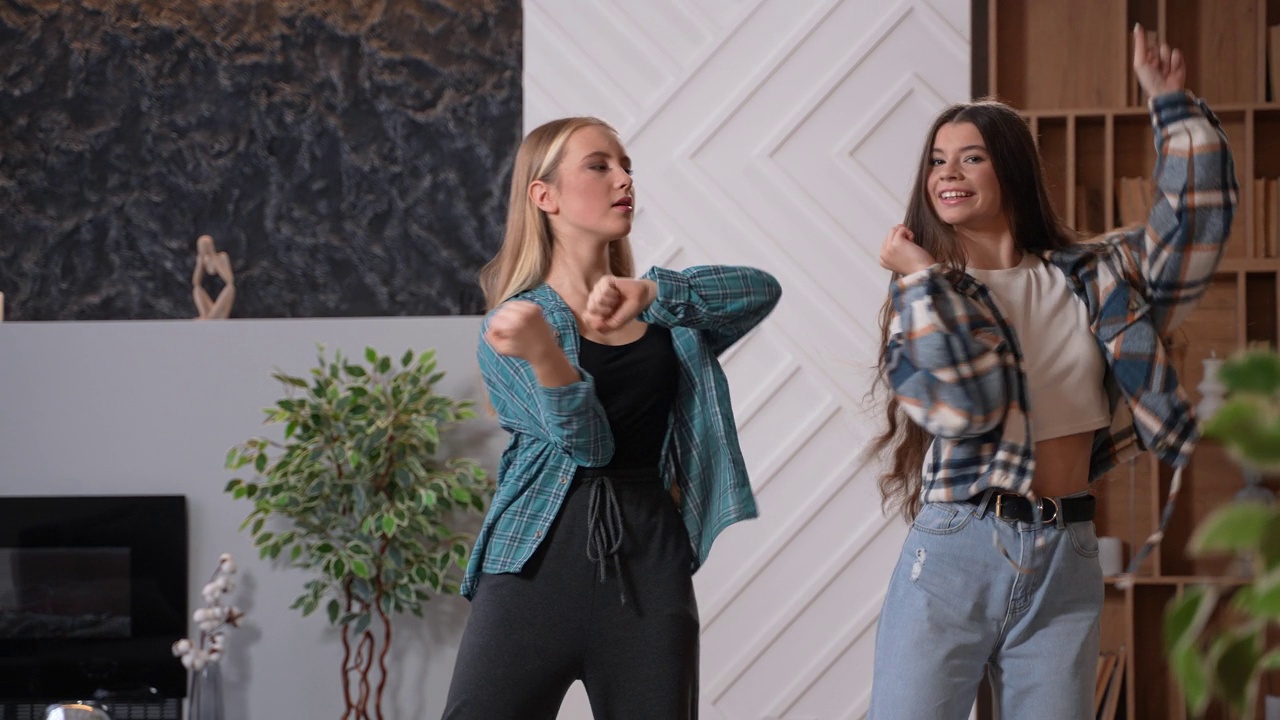 年轻的女性朋友在客厅里录制舞蹈视频下载