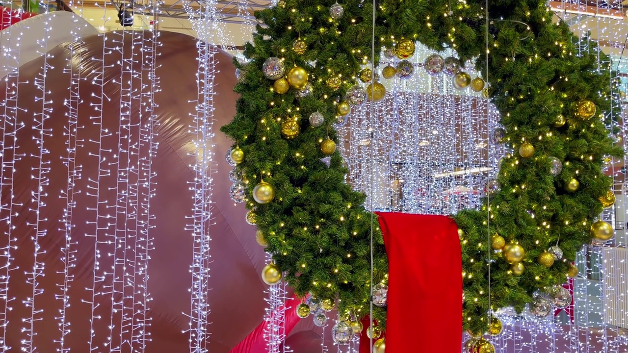 购物中心的圣诞绿色皇冠，金色的球和白色的灯串视频下载