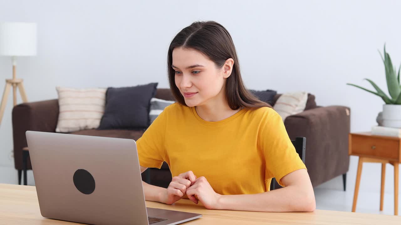 年轻女性自由职业者或学生做一个视频电话在家里使用笔记本电脑视频下载