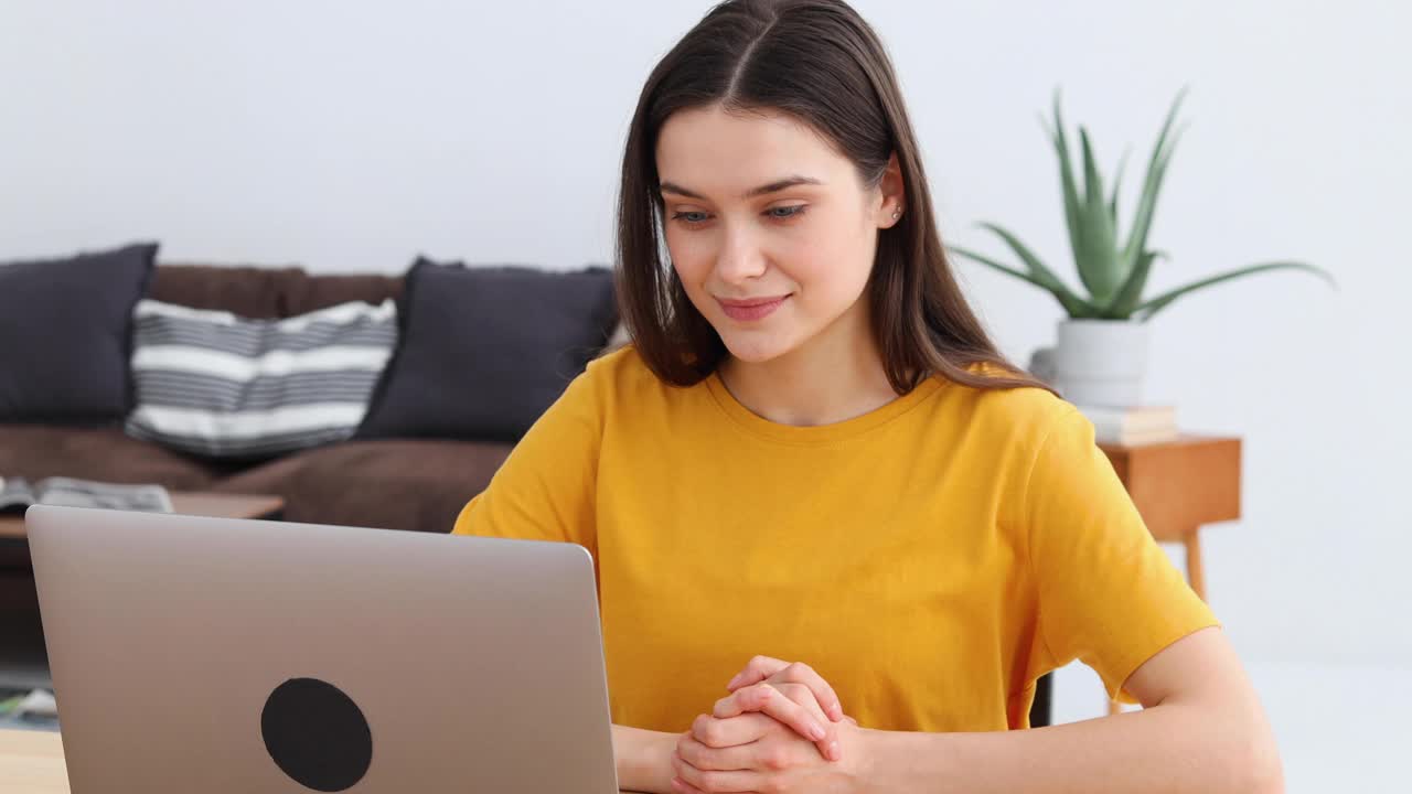 年轻女性自由职业者或学生做一个视频电话在家里使用笔记本电脑视频下载