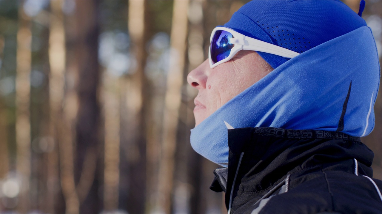 男子戴着滑雪镜在冬天探索森林的特写镜头视频下载