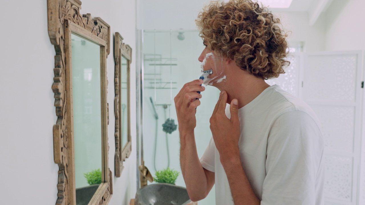 男人，在浴室镜子里洗脸或刮胡子，进行早上的例行美容，保健或卫生维护。剃须器、奶油或泡沫，用于脱毛清洁或面部护肤产品视频下载