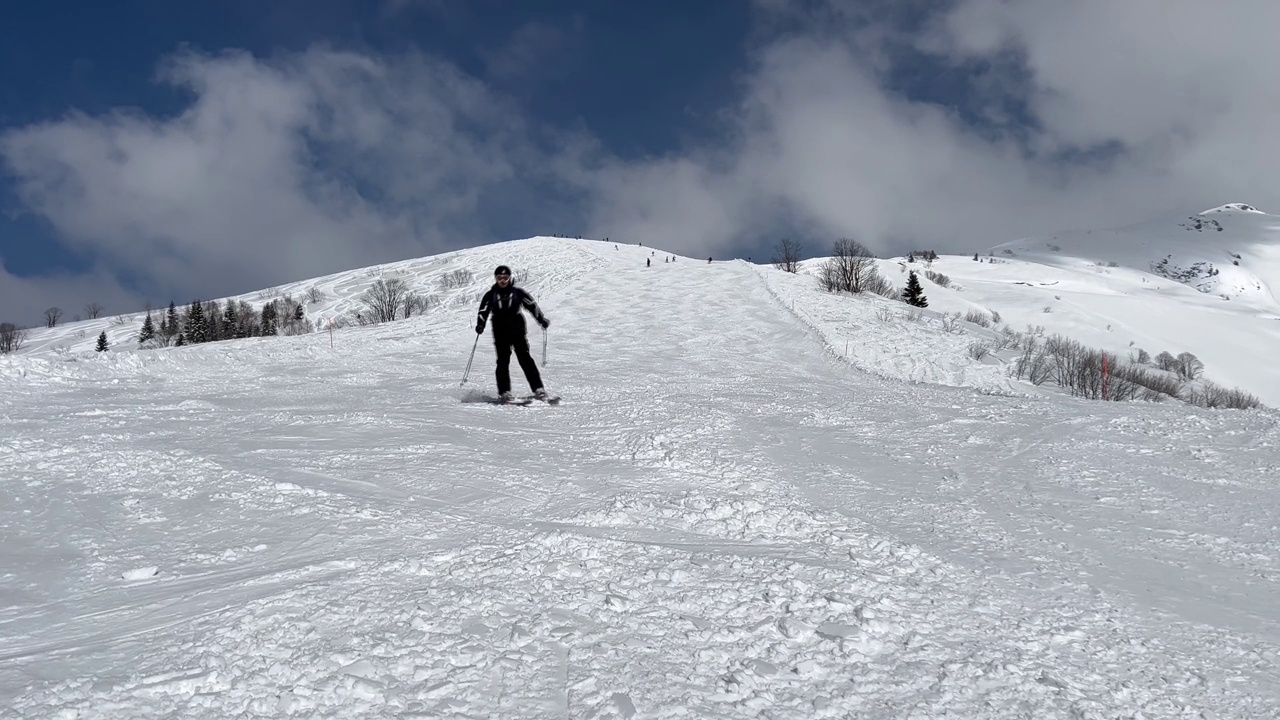 滑雪者在阳光明媚的冬日在雪山滑雪视频素材