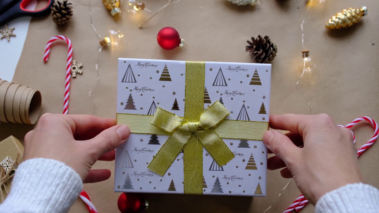 钥匙的房子与钥匙链上舒适的家在礼盒与圣诞装饰包装。为新年、圣诞节打包礼物。建筑，项目，搬新房，抵押，租赁，购买房地产视频下载