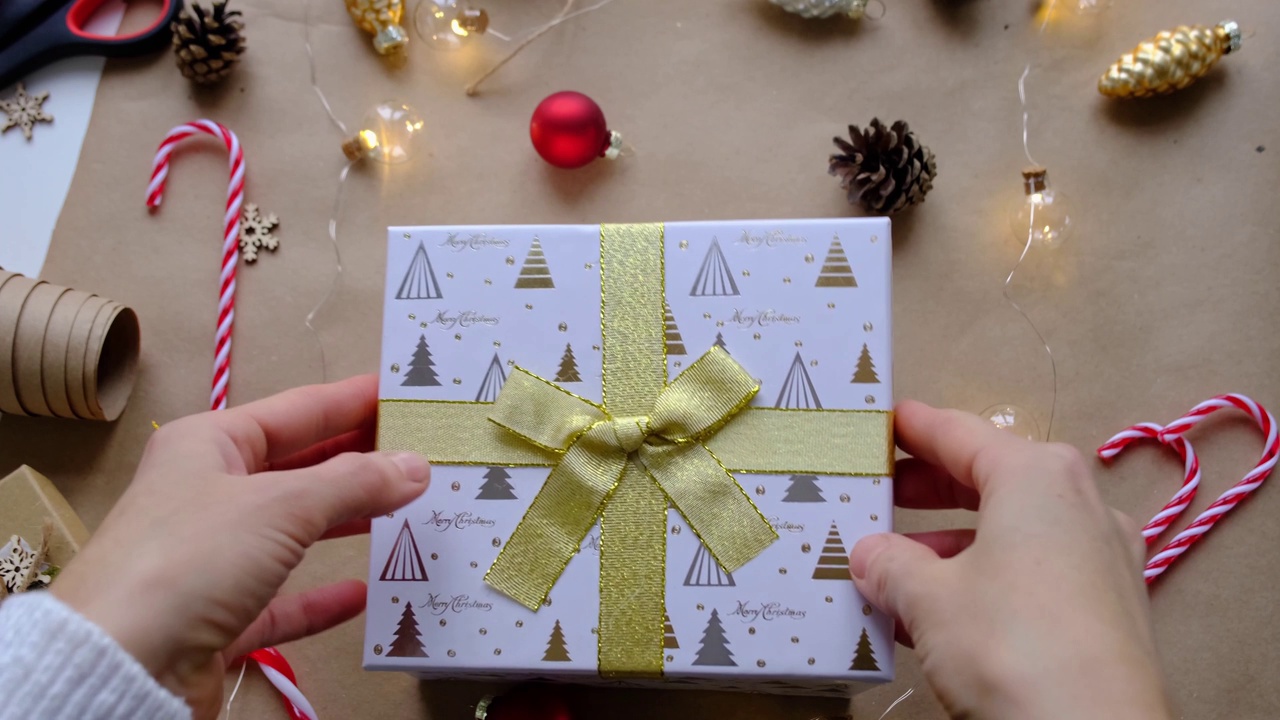 钥匙的房子与钥匙链上舒适的家在礼盒与圣诞装饰包装。为新年、圣诞节打包礼物。建筑，项目，搬新房，抵押，租赁，购买房地产视频素材