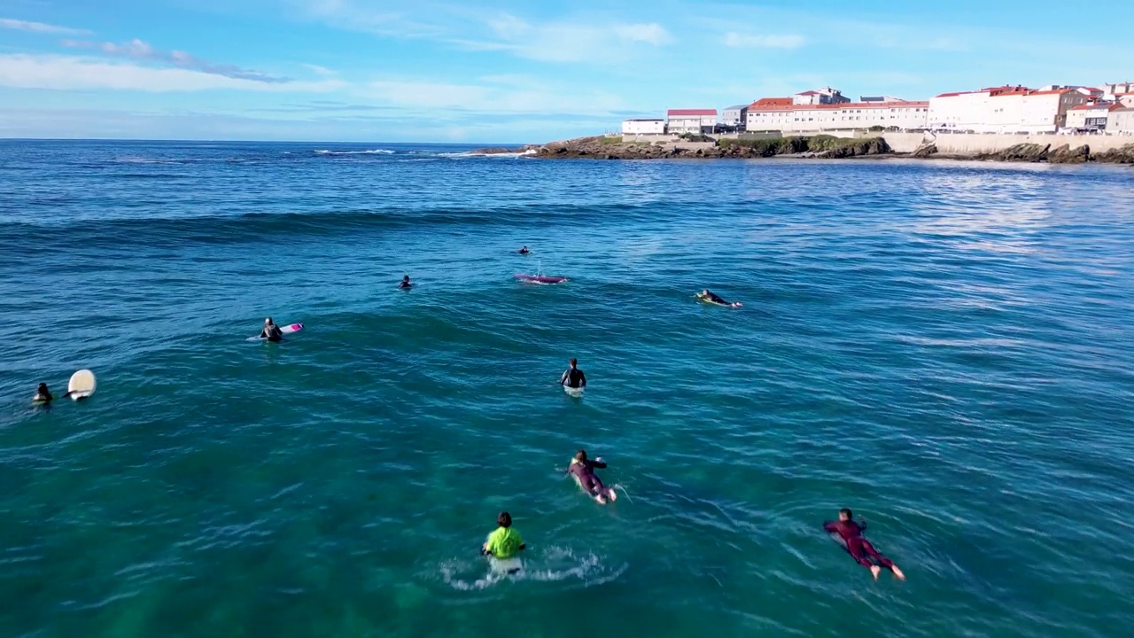 冲浪者游泳和坐在冲浪板上的鸟瞰图视频素材
