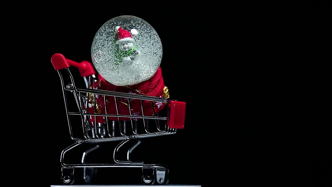 镜头的手推车玻璃球雪人人物深色背景视频下载