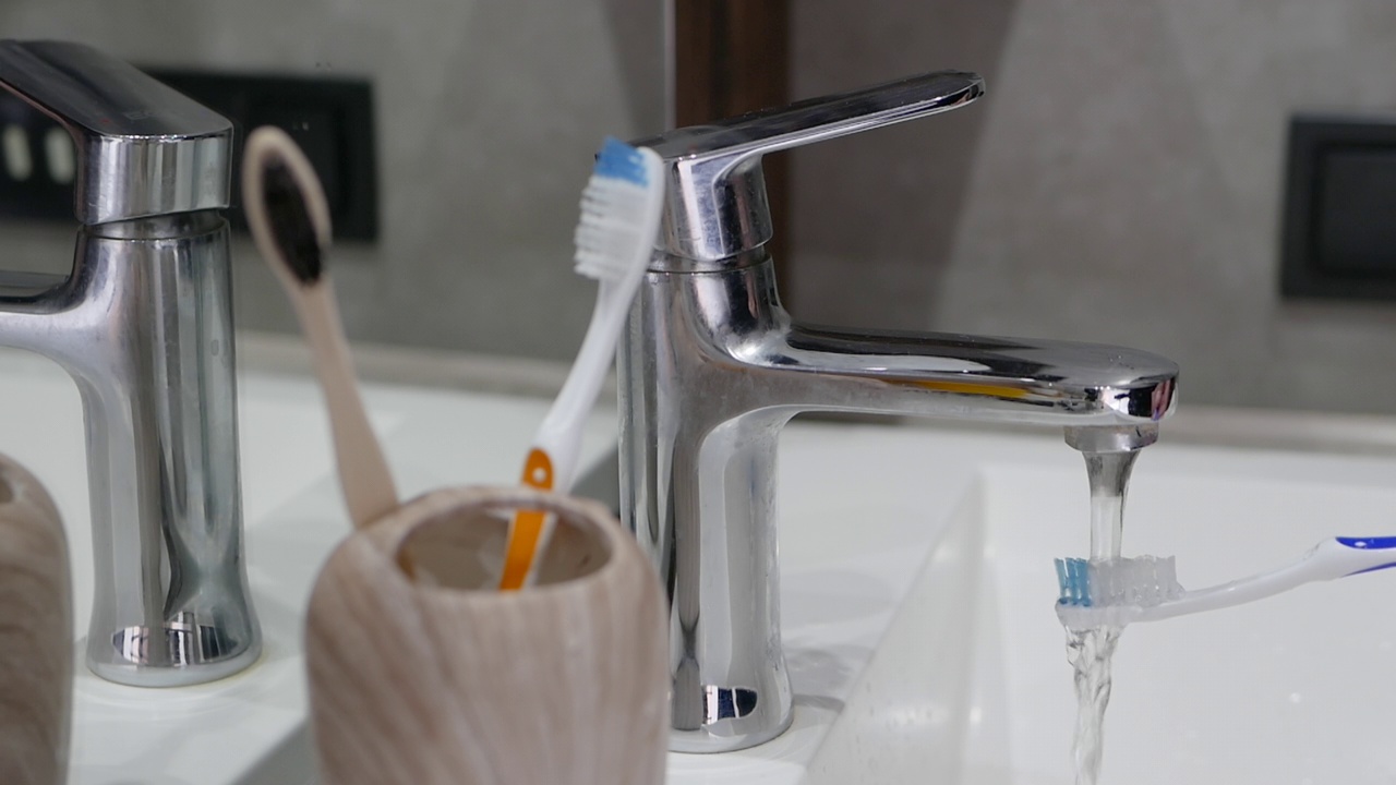 把牙刷放在水槽里清洗，把牙刷放在浴室的盒子里视频素材