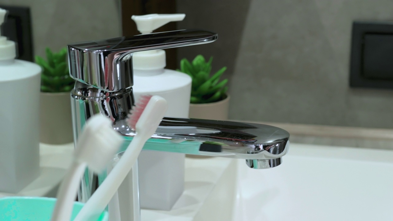 一个男人的手从浴室的箱子里拿起一把牙刷。牙齿卫生，在浴室刷牙视频素材