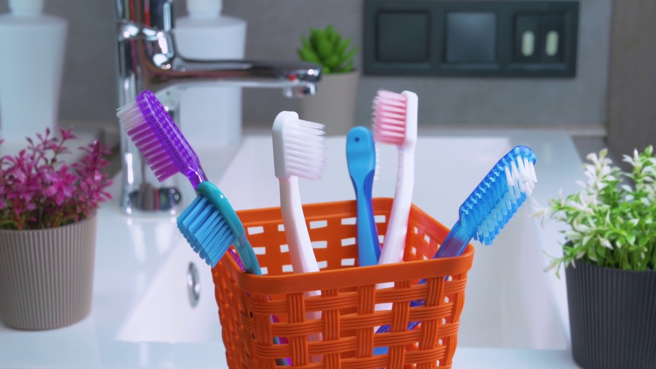 浴室转盘上的橙色篮子里有很多牙刷。牙科保健。转动牙刷。牙齿清洁视频素材