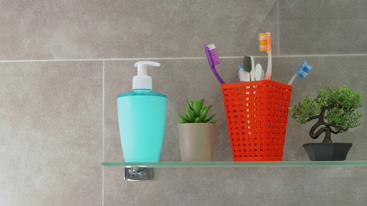 浴室里橙色篮子里的牙刷的定格动画。健康牙齿的概念。浴室玻璃架子上五颜六色的牙刷。视频下载