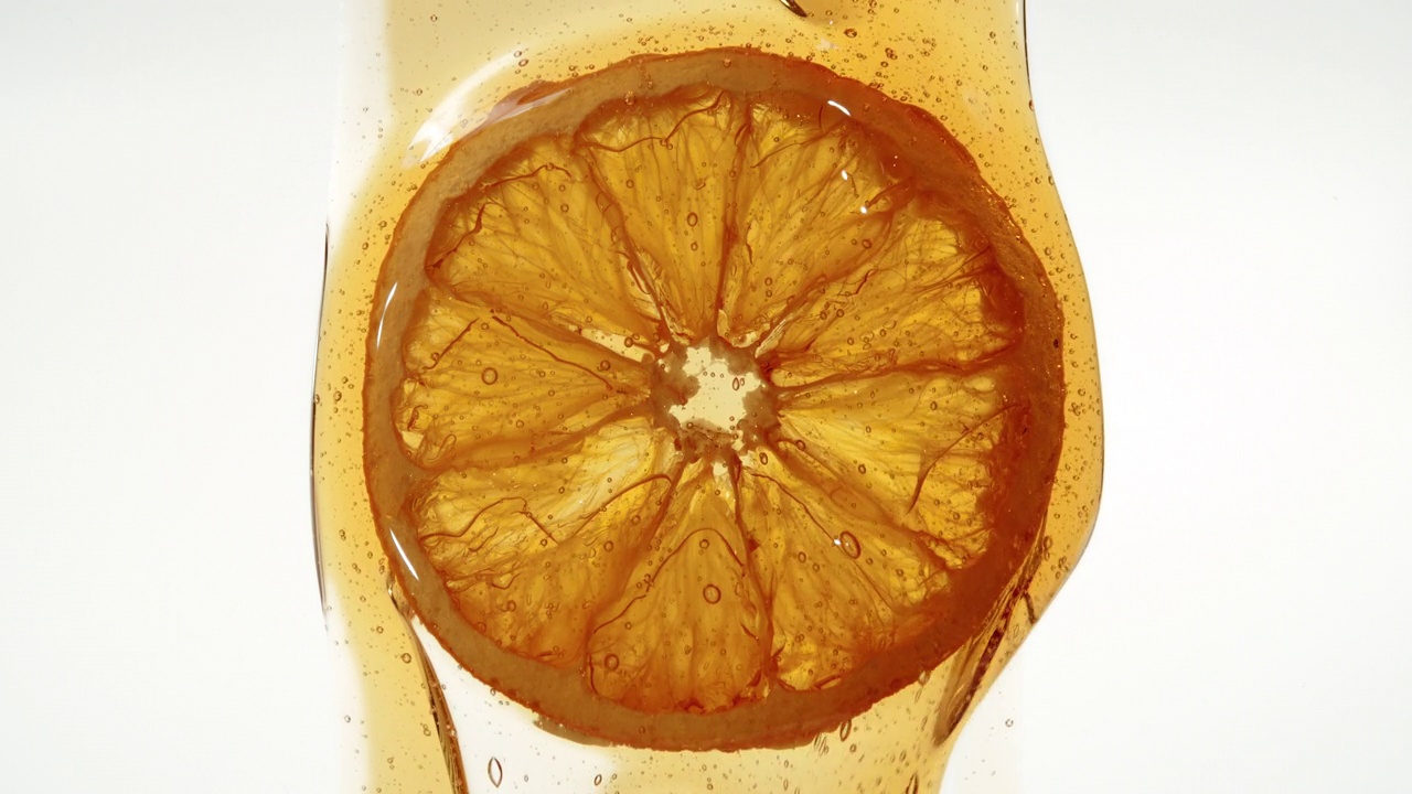干橙片滴焦糖滴甜酱或蜂蜜，脱水柑橘和流动糖浆滴视频下载