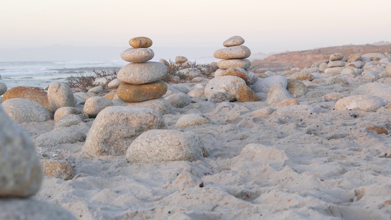 卵石海滩上的岩石平衡。金字塔的石头堆，海岸，海水视频下载