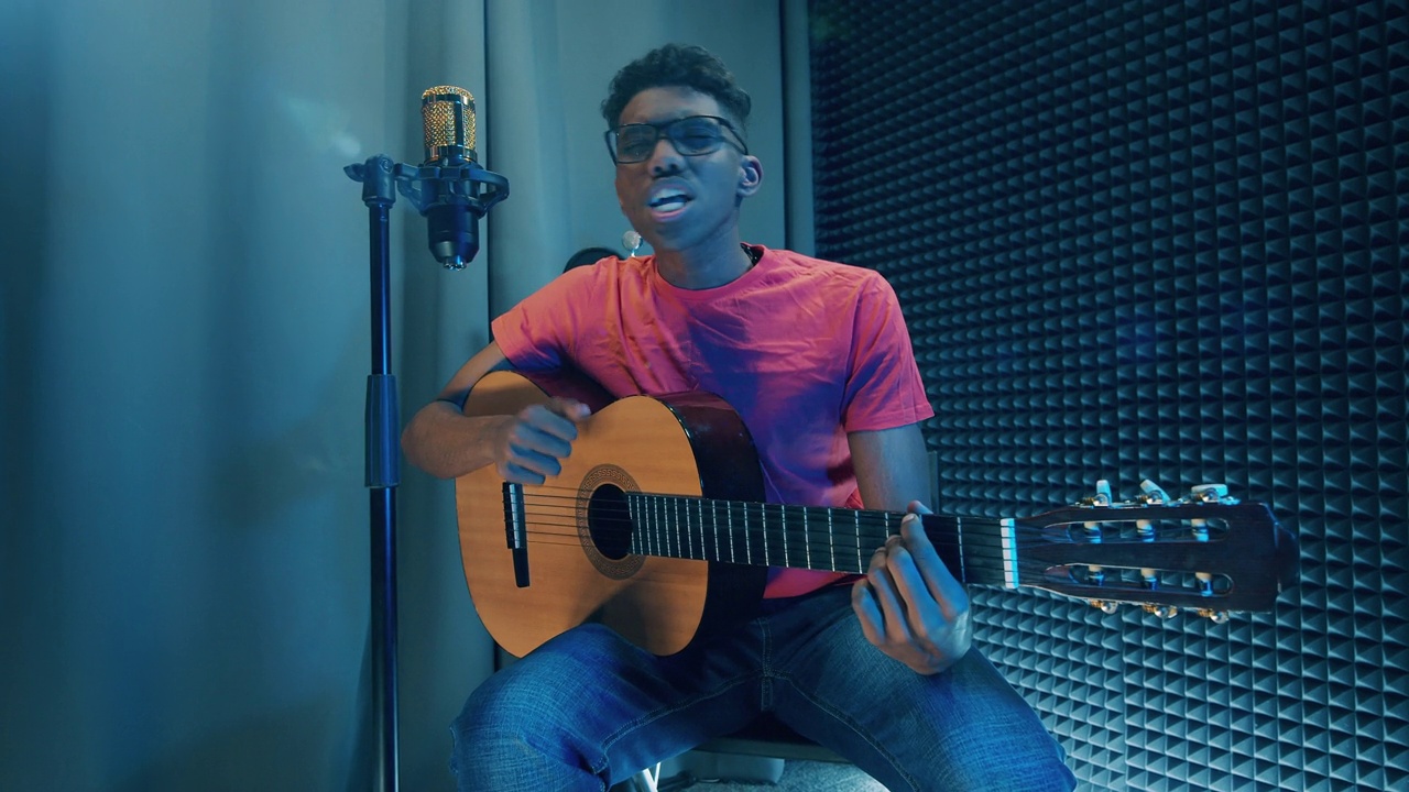 年轻的非洲裔美国人在演播室里弹吉他唱歌视频下载