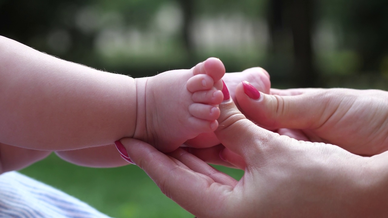 特写女性的手抚摸婴儿的脚视频下载