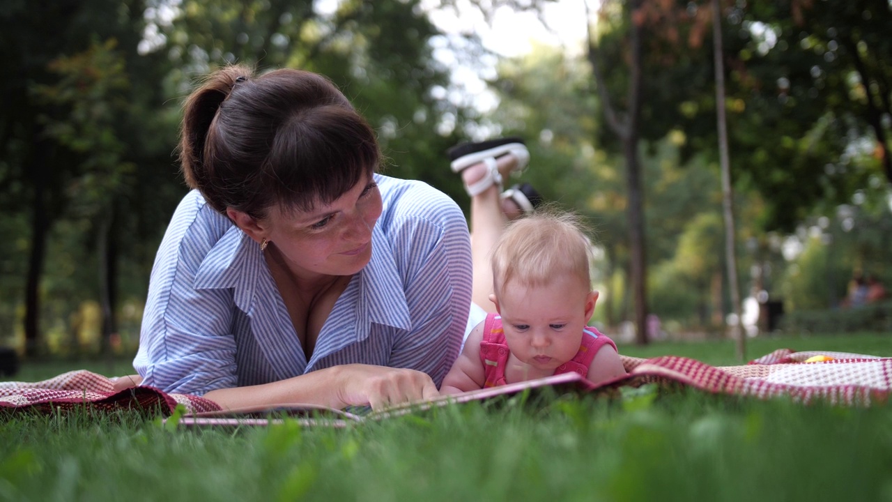 女性在户外给宝宝读书视频下载