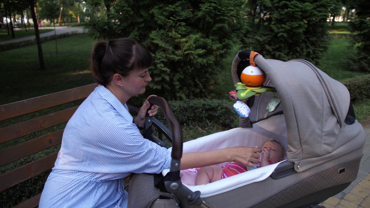 小女婴躺在公园的婴儿车里视频下载