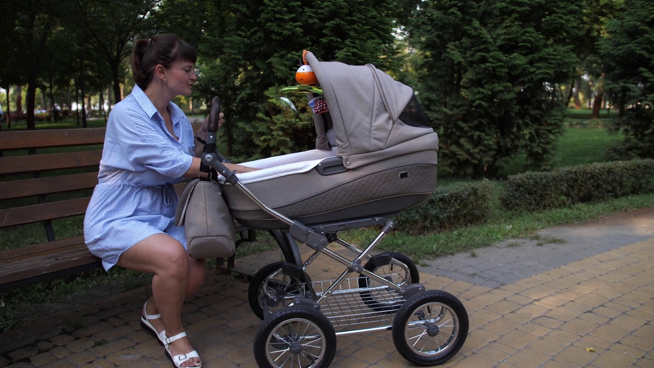 女性在婴儿车里和婴儿玩耍视频下载