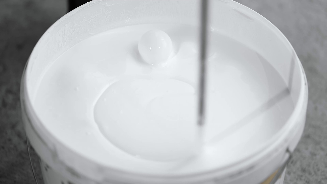 建筑搅拌器将白色涂料与气泡混合视频下载