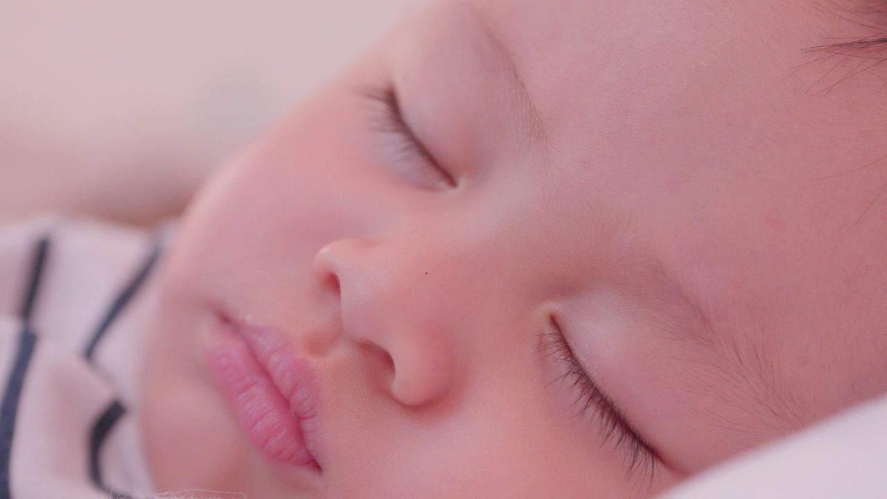 在婴儿脸亚洲人睡在床上的眼睛睫毛的特写肖像。当可爱的新生婴儿在卧室睡觉。天真的小婴儿可爱。为人父母和母亲节的概念。视频素材