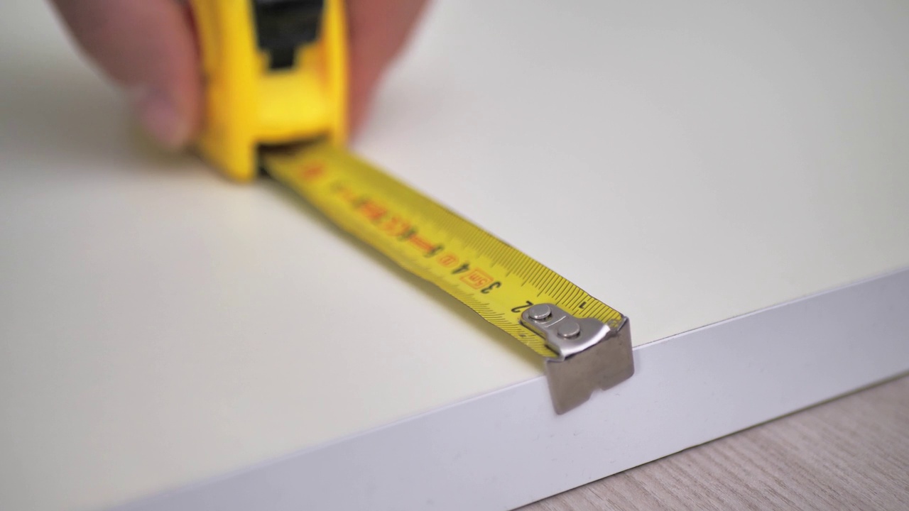 测量卷。一个男人用卷尺测量白板视频素材