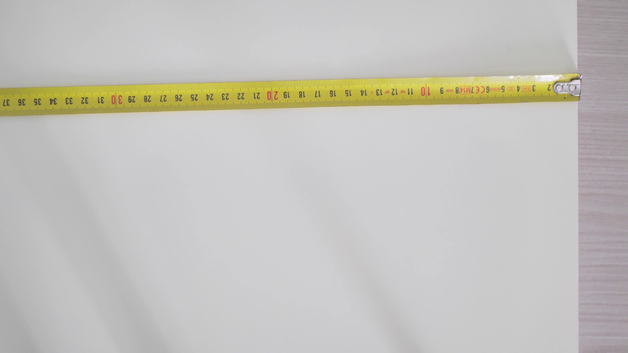 测量卷。一个男人用卷尺测量白板视频素材