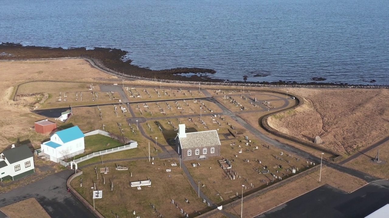 飞往冰岛大西洋海岸线上有墓地的小教堂，空中视频下载