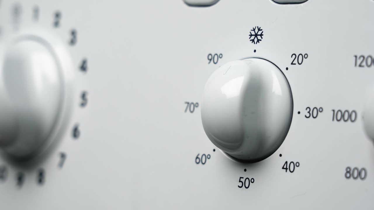 一只手在洗衣机上设定温度的特写镜头视频下载