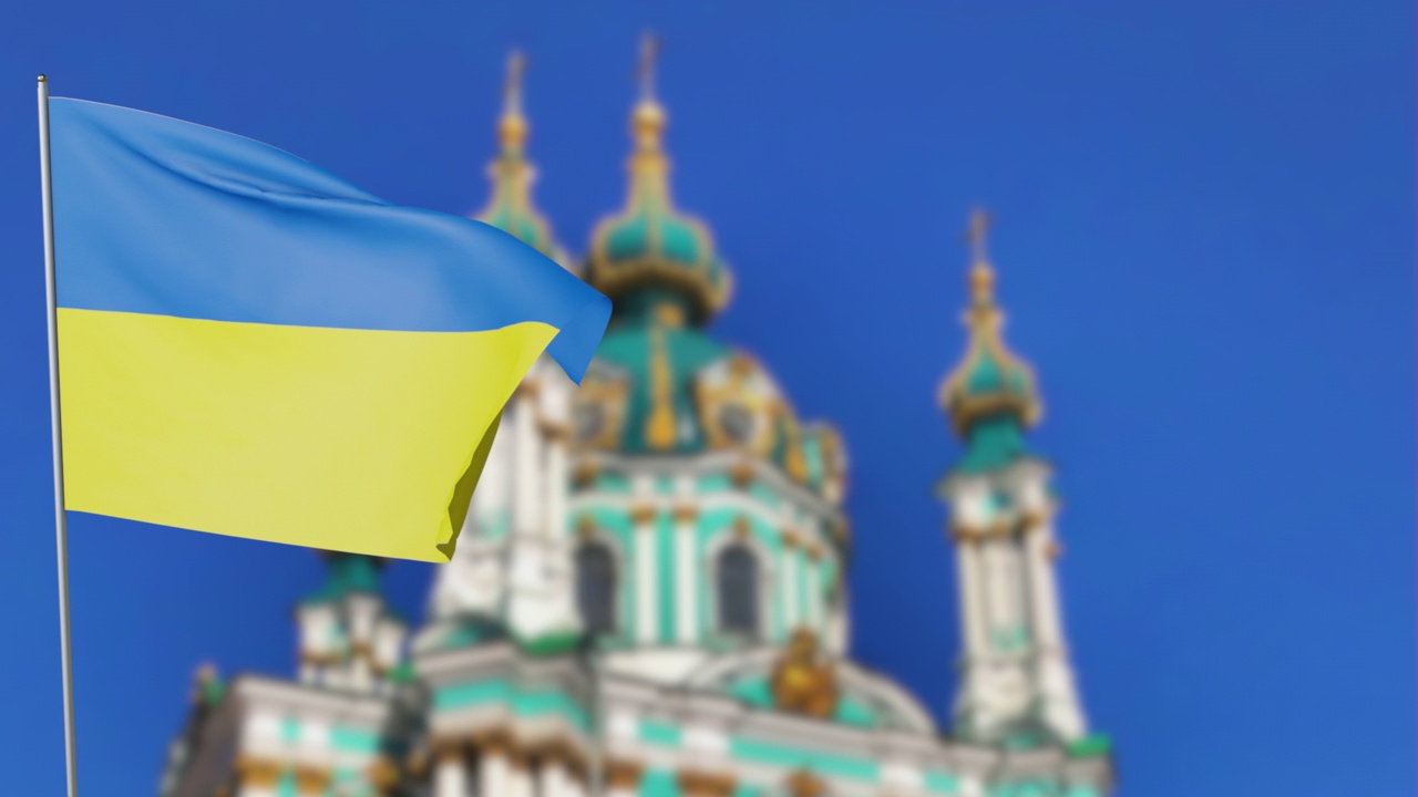 乌克兰国旗在基辅市中心的乌克兰地标圣安德鲁教堂的背景下飘扬。乌克兰自由国家的国旗视频下载