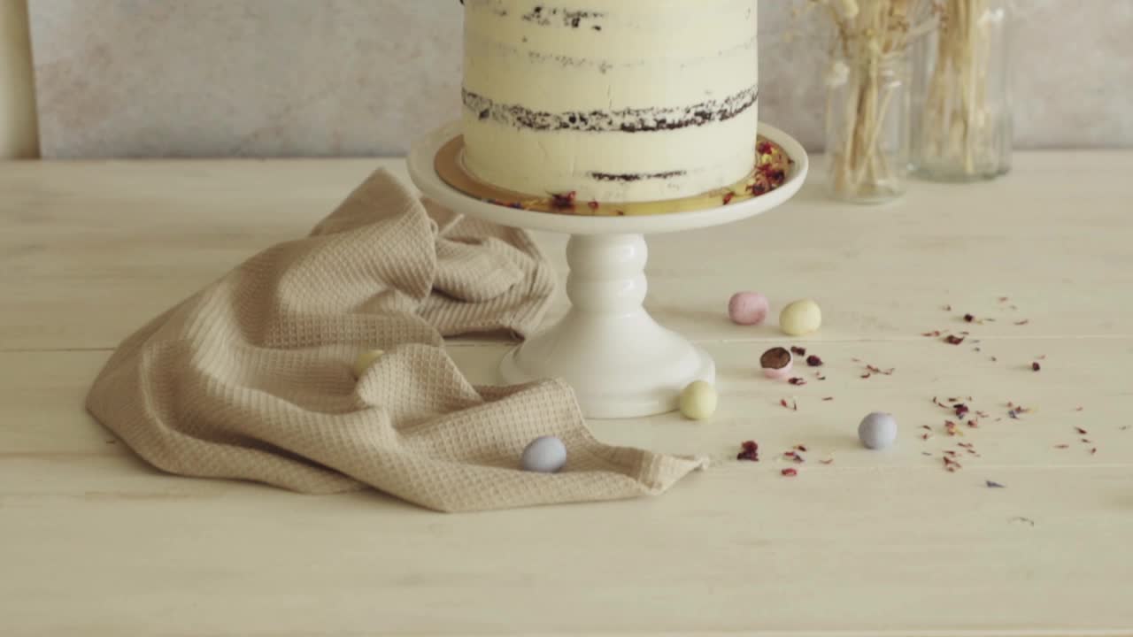 一个美味的复活节Frohe Ostern裸蛋糕放在白色装饰的桌子上的4K特写镜头视频下载