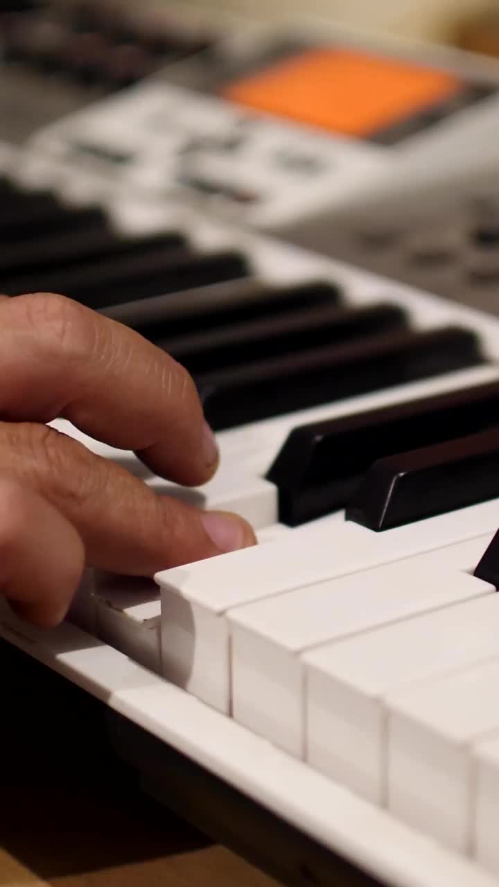 垂直视频的一个手演奏电子键盘的中镜头视频下载