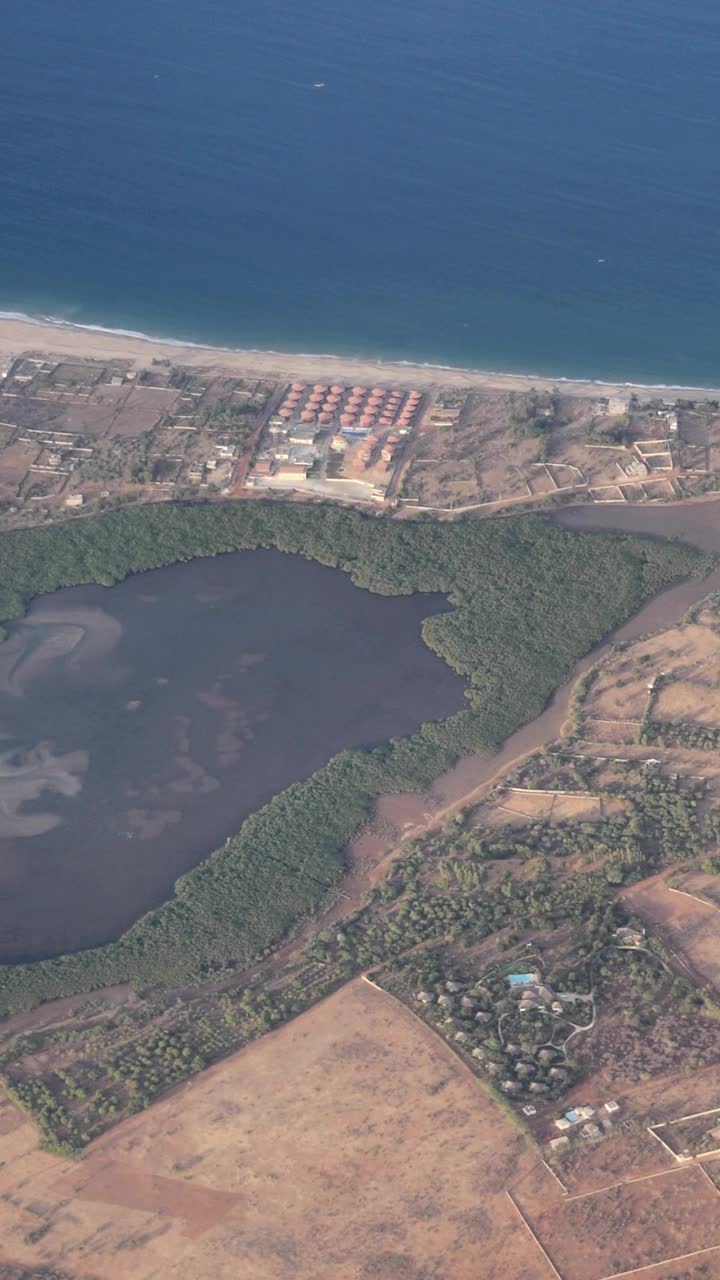 垂直视频河三角洲红树林沿塞内加尔海岸，建筑靠近海岸视频下载