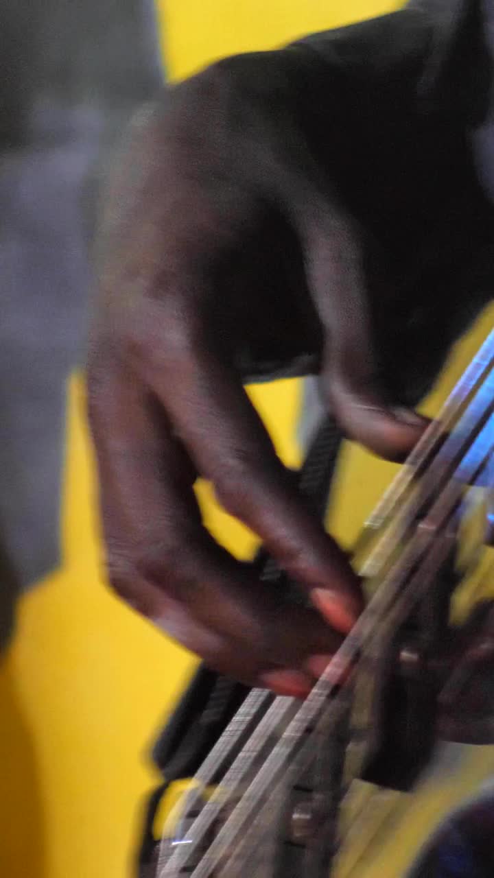 垂直视频的黑手玩黑色电贝斯吉他与灯光秀视频下载