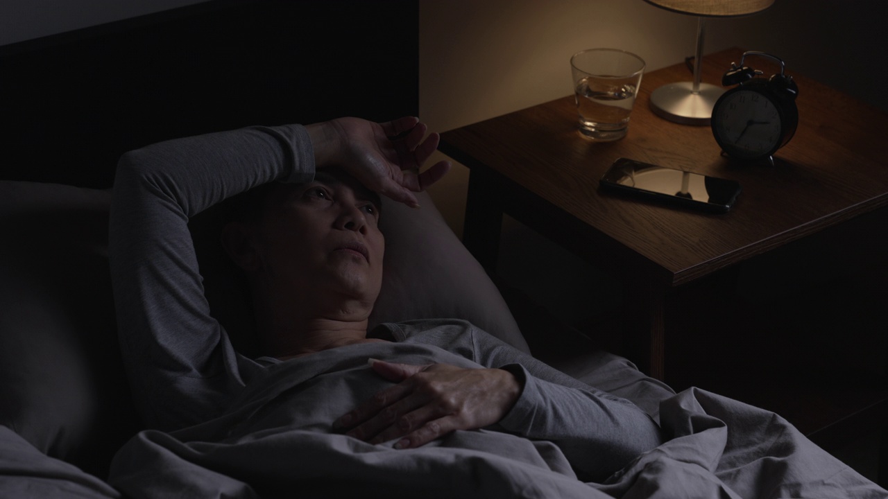 延时拍摄:抑郁的亚洲老年妇女因失眠而无法入睡。视频下载