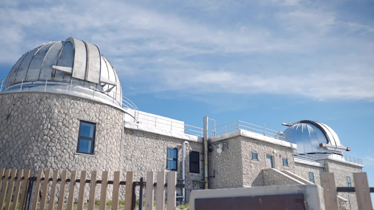 天文观测站位于山区丘陵附近，为监测外太空和研究行星地球的石头建筑，金属圆圆顶，用于接收与太空的通信连接视频下载