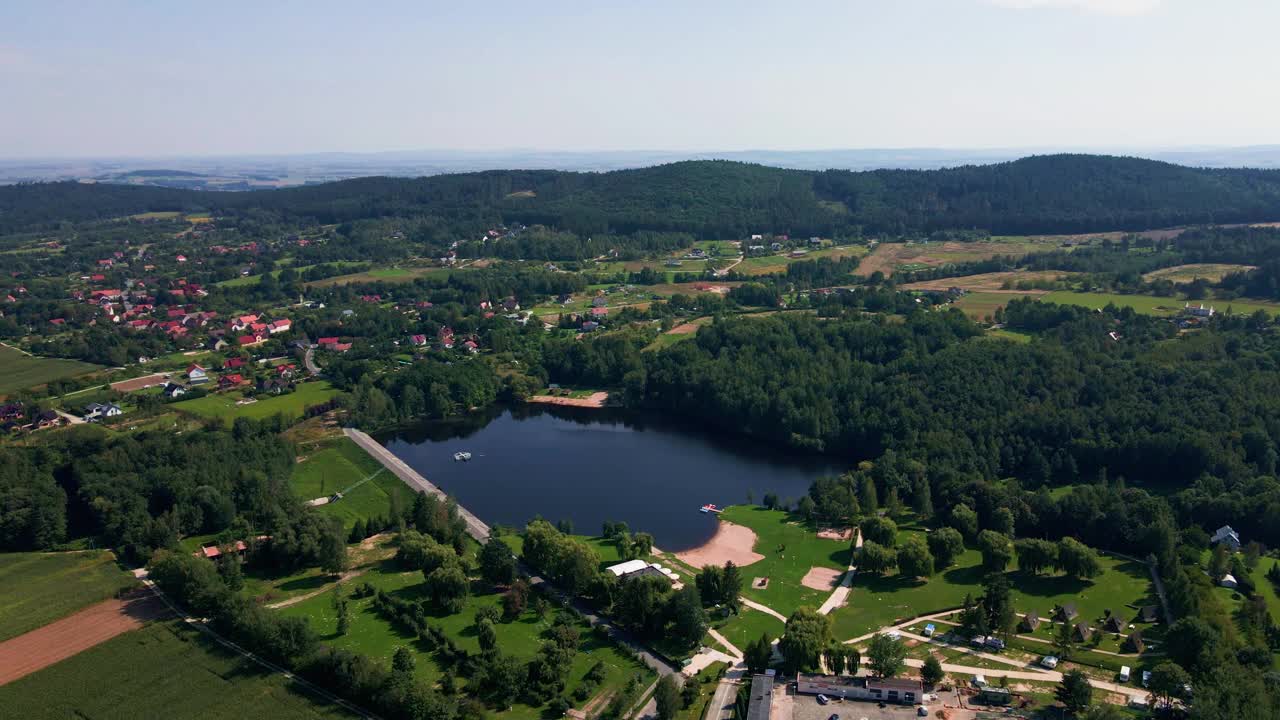 夏日山上村庄和湖泊的鸟瞰图视频素材