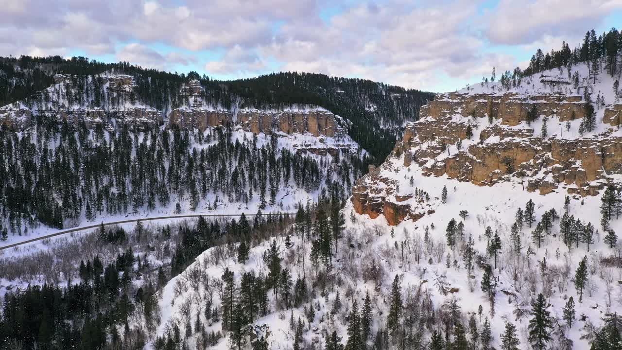 在冬天大雪纷飞的山谷中蜿蜒的道路视频素材