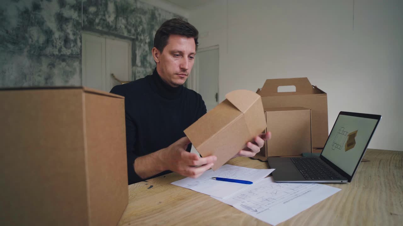 在家做自由职业。设计师在电脑上创建纸箱包装设计视频下载