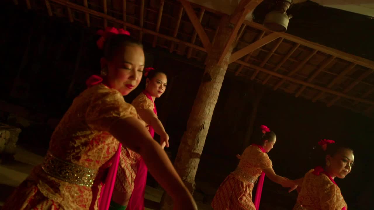 印尼人在温暖的灯光下快乐地跳舞，身上穿着橙色的衣服视频素材