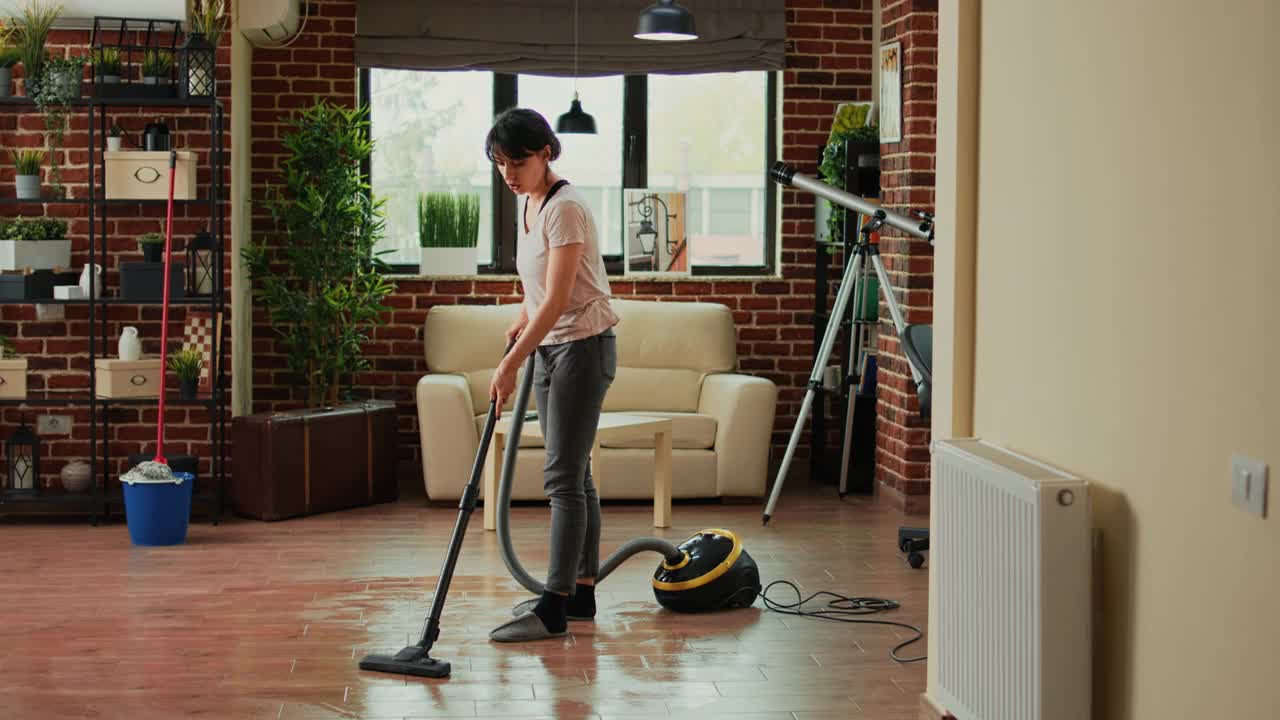 现代家庭主妇在公寓里用拖把扫地视频素材