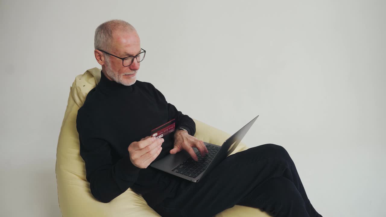 在线购物。上了年纪的时尚男士在电脑上输入信用卡信息。视频素材