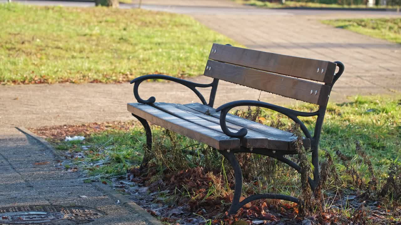 在寒冷的早晨，木制的公园长椅上覆盖着白霜霜冰视频下载
