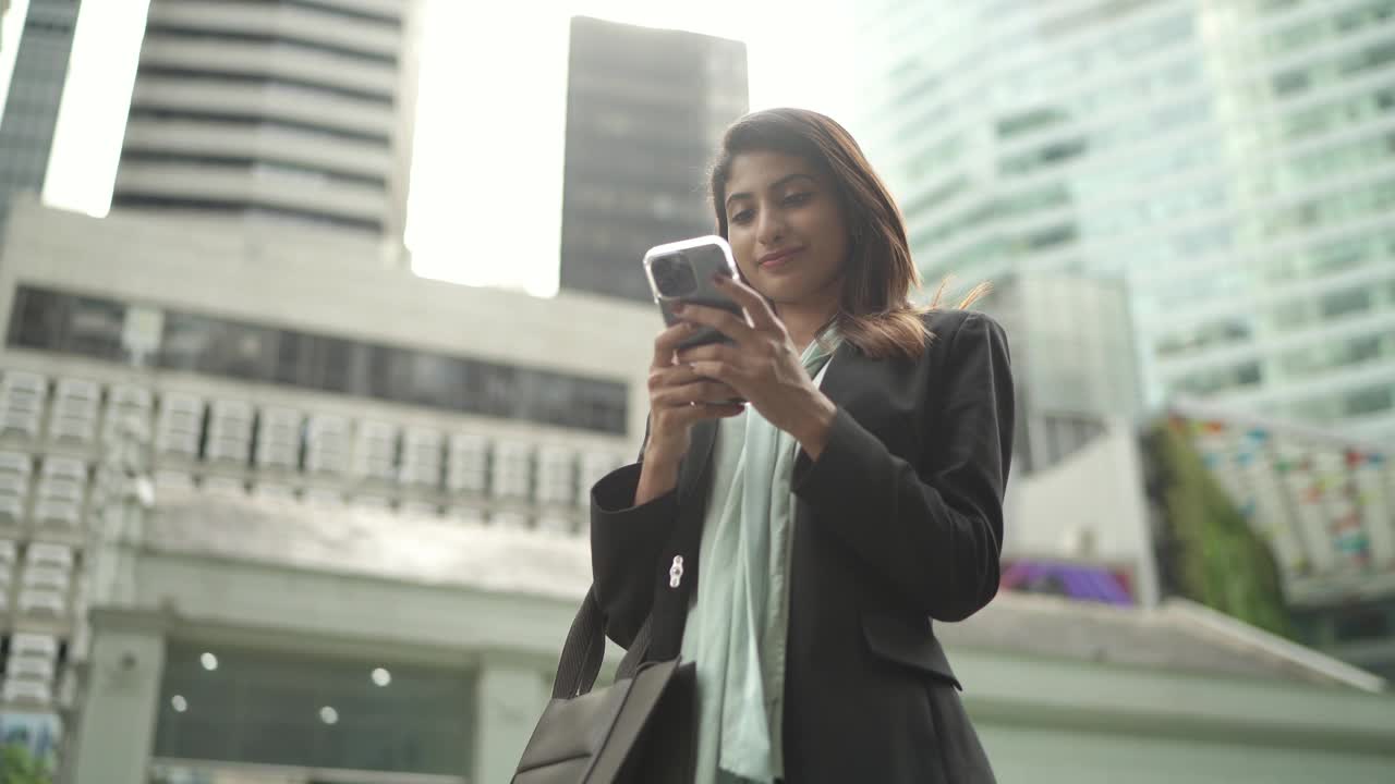 亚裔印度女商人在新加坡中央商业区上班途中打电话视频下载