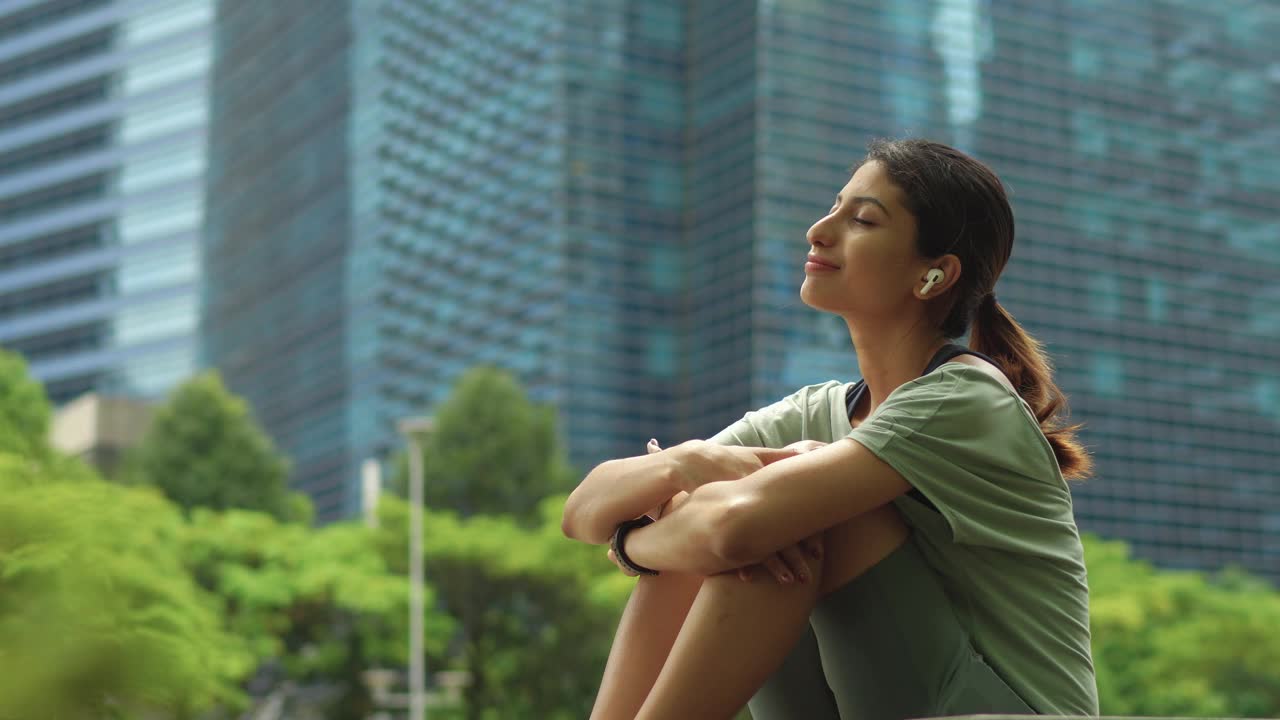 快乐的亚洲印度女子在听音乐跑步后休息视频下载