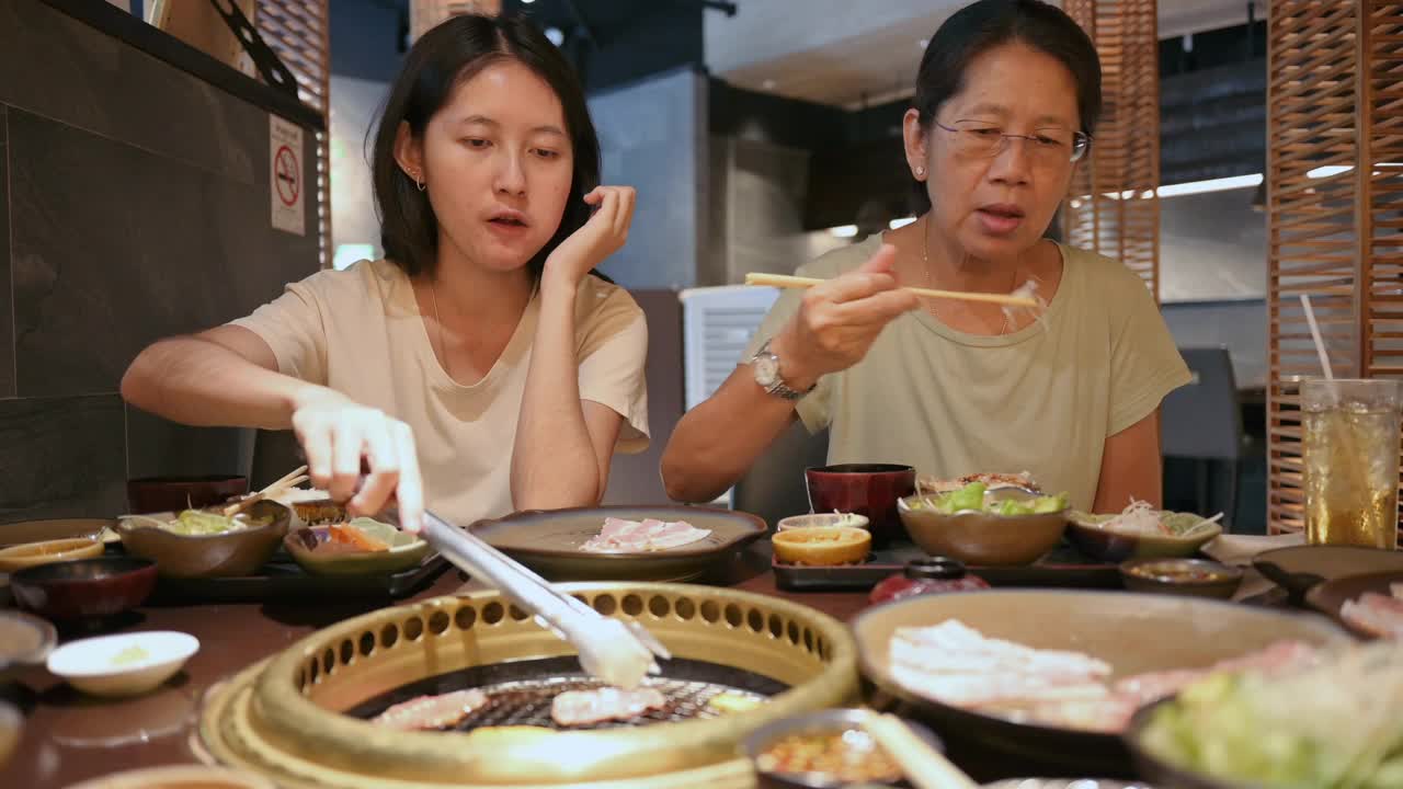 快乐的亚洲泰国人用餐和品尝日本风味的牛肉与家人的快乐时刻视频下载