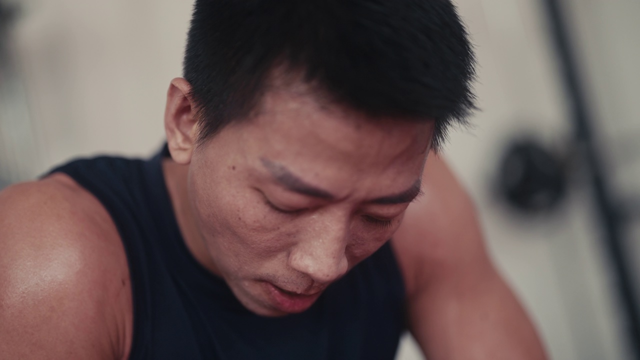 肌肉发达的亚洲男性在健身房使用举重机视频素材