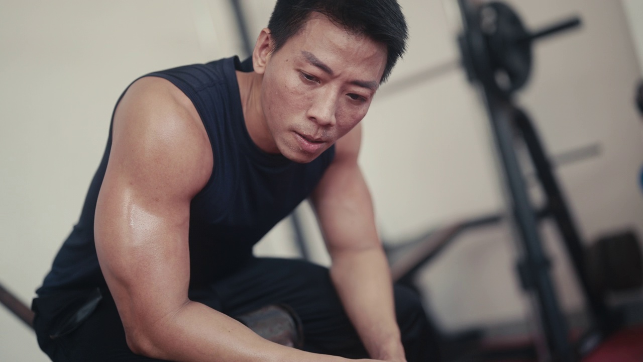 肌肉发达的亚洲男性在健身房使用举重机视频素材