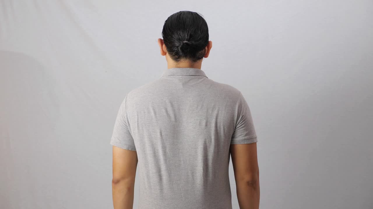 空白领衬衫模拟模板，后视镜，亚洲男模穿着纯灰色t恤孤立在白色上。马球衫设计模型演示视频下载