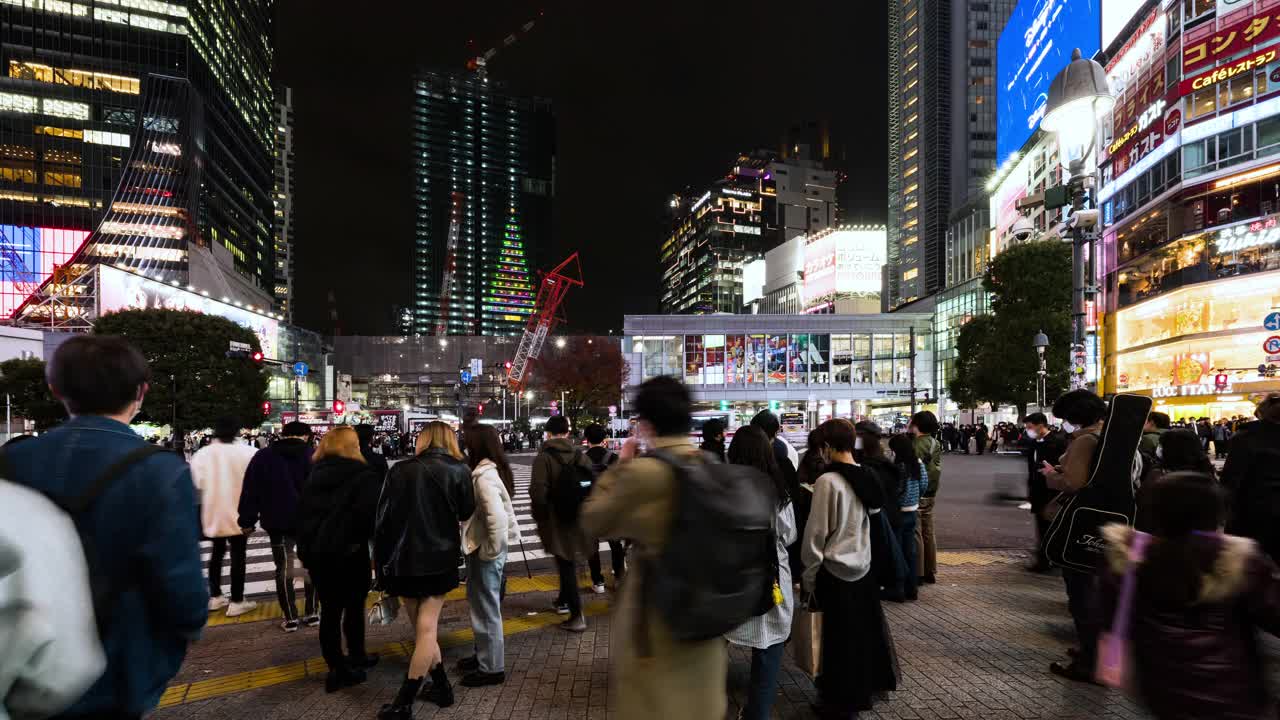 夜间时间流逝的汽车交通运输，拥挤的人走在涩谷路口的十字路口争抢。东京旅游景点地标，日本旅游，亚洲交通或亚洲城市生活理念视频素材